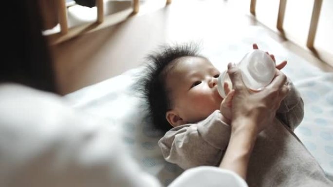 亚洲母亲正在用奶瓶母乳喂养
