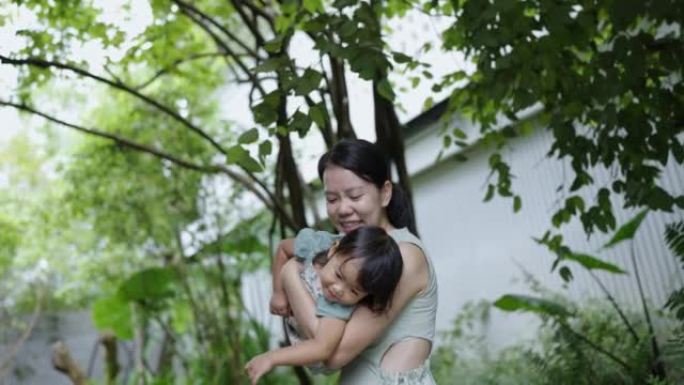 怀孕的亚洲母亲带着她的女婴玩耍，让她感觉像一架飞行的飞机或超人。