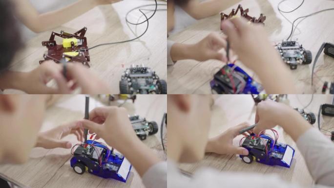 一名高中生正在使用螺丝刀修理机器人汽车，另一名学生正在使用操纵杆控制蜘蛛腿机器人汽车。