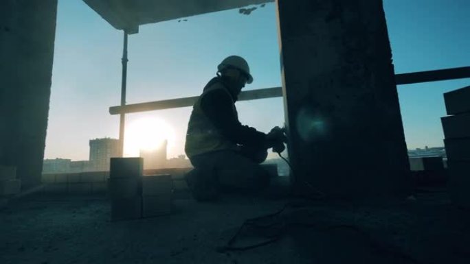 穿着制服的工人在日落背景上打磨墙壁。