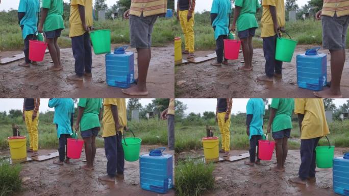 年轻的非洲黑人男孩在公共取水点排队取水供家庭使用。水危机。贫困。气候变化。全球变暖。干旱