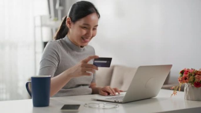 女人在家用笔记本电脑在线购物