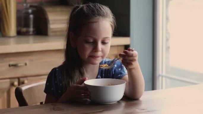 快乐可爱的小女孩吃牛奶燕麦片。