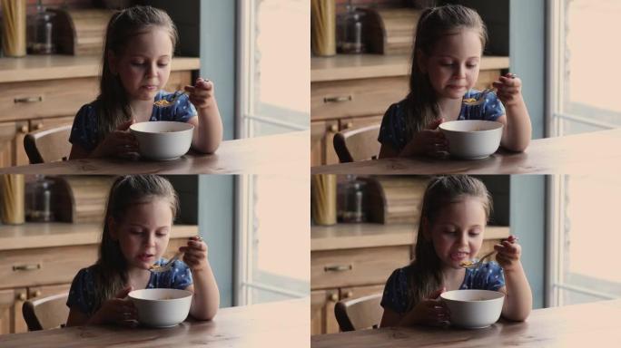 快乐可爱的小女孩吃牛奶燕麦片。