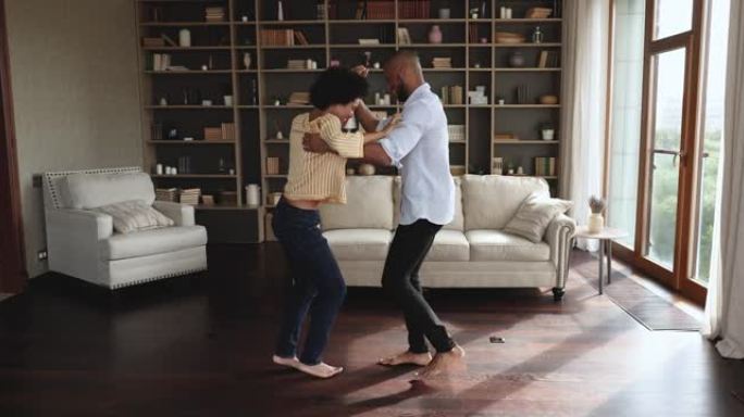 全长快乐的非洲夫妇在客厅赤脚跳舞