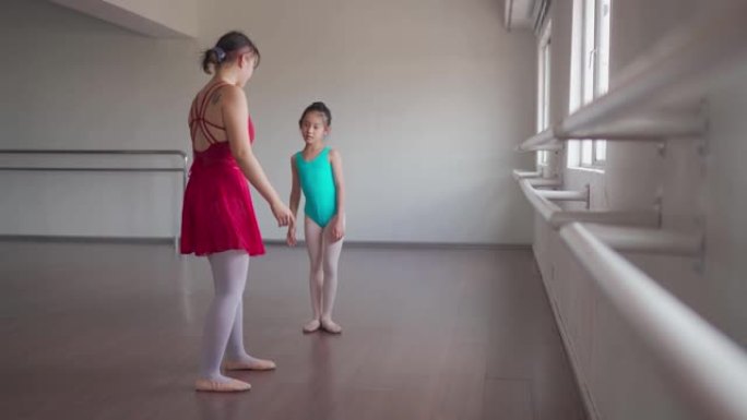 亚洲中国少女芭蕾舞演员在工作室训练她的年轻女学生