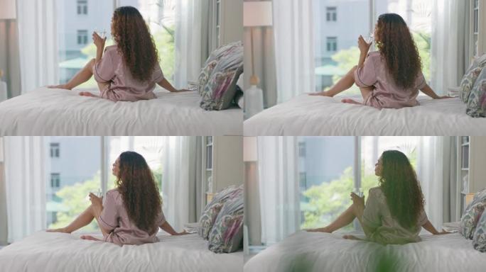 4k视频片段，一名年轻女子在床上放松并在家喝咖啡