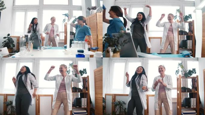 快乐的乐趣兴奋的多民族女医生一起跳舞，庆祝在诊所工作场所战胜冠状病毒。