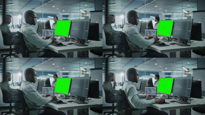 多民族办公室: 黑色IT程序员在电脑上工作，绿屏色度键显示。男软件工程师开发应用程序，程序，视频游戏