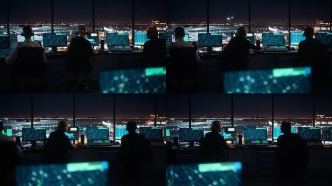 夜间在现代机场塔台工作的多元化空中交通管制团队。办公室里满是台式电脑显示屏，配有导航屏幕、飞机起飞和