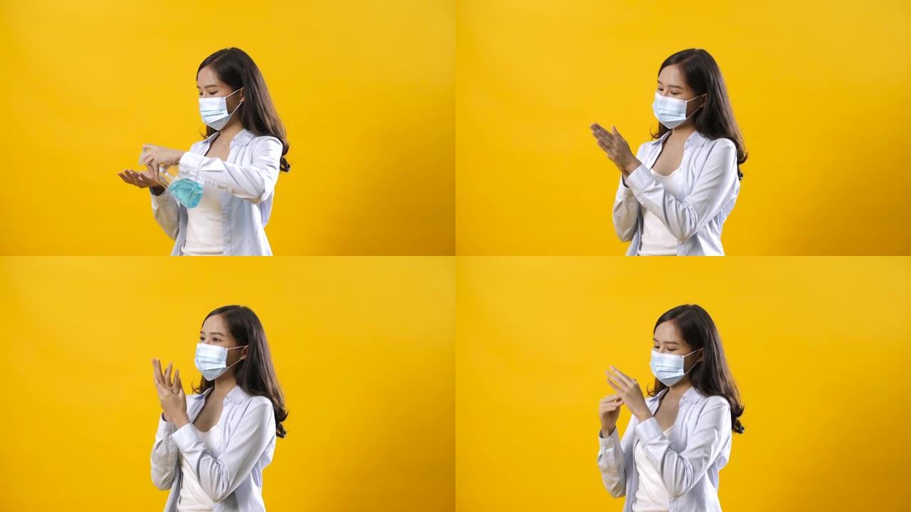 美丽的亚洲女人戴上防护医用口罩，在工作室黄色背景下洗手