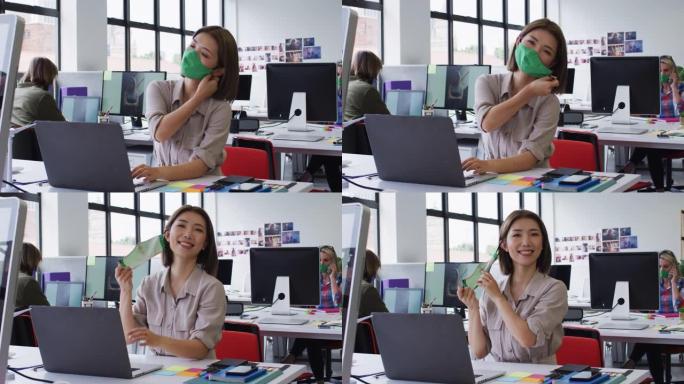 亚洲妇女在现代办公室摘下面罩的肖像