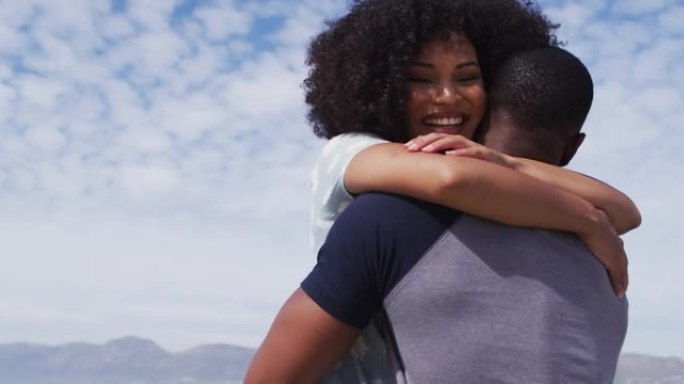 非裔美国夫妇在海滩上拥抱和微笑