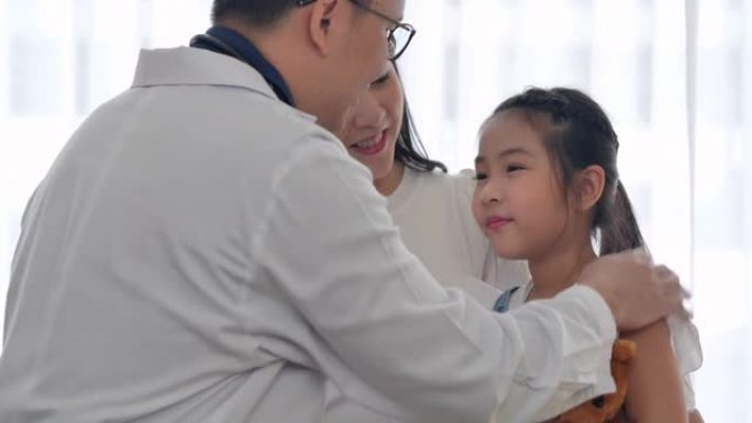 亚洲6岁小女孩的幸福坐在医院时向亚洲儿科医生男性抚摸手。医患咨询理念。