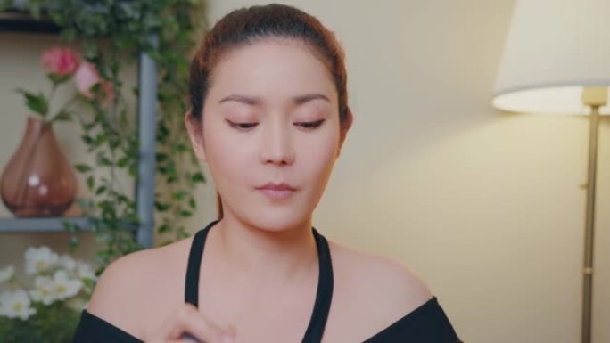 特写亚洲女性youtube影响者教学如何使用哑光液体口红在线教程在家。