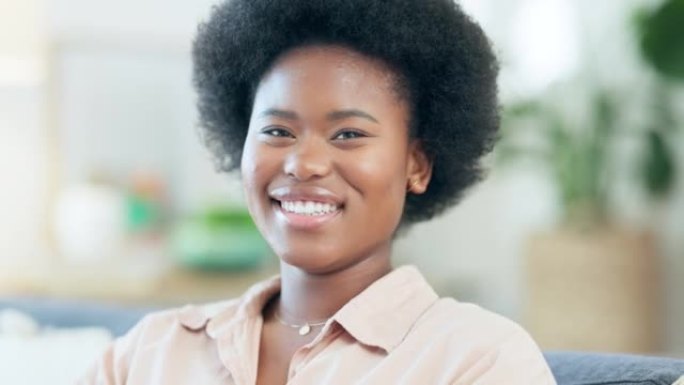 快乐的非洲女人，一个非洲人在家里笑着咯咯笑。一位美丽的黑人女性的脸部肖像，展现出她完美的牙齿和微笑。