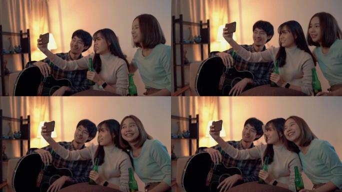 年轻的亚洲朋友在家里的私人聚会上在智能手机上集体自拍。