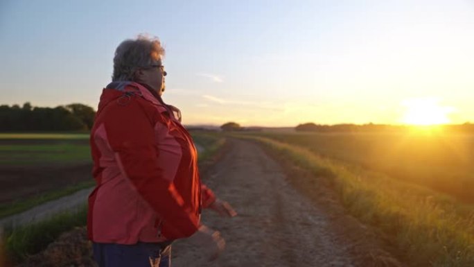 WS一名老年妇女在日落时做伸展运动