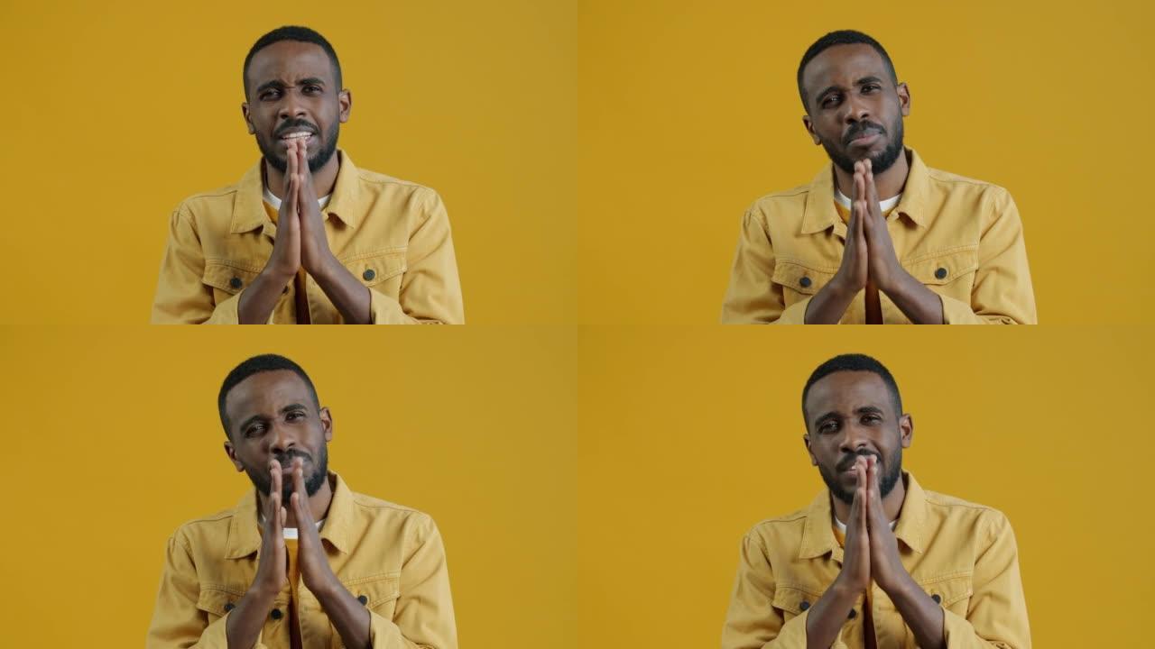悲惨的非洲裔美国人的慢动作肖像乞求祈祷手势的帮助