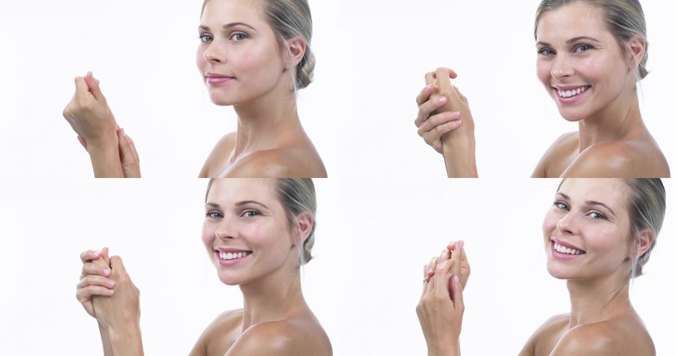 4k视频片段，一位迷人的年轻女子在白色工作室背景下使用手部保湿霜