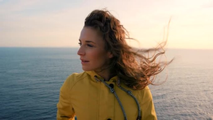 4k视频片段，一位迷人的年轻女子在大洋前徒步旅行时独自站立