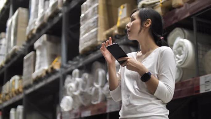 亚洲妇女在仓库中使用智能手机