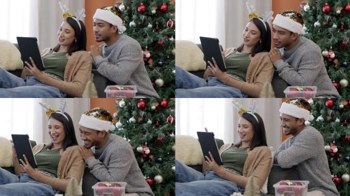 一对年轻夫妇在家中一起在沙发上使用数字平板电脑进行圣诞节最后一刻购物的4k视频片段