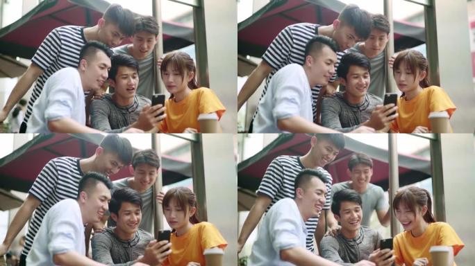 年轻的亚洲男人和女人一起在户外看手机