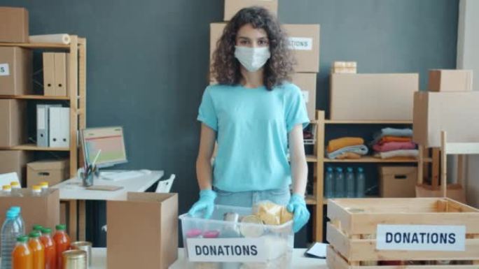 慈善基金办公室戴口罩的女性志愿者的慢动作肖像