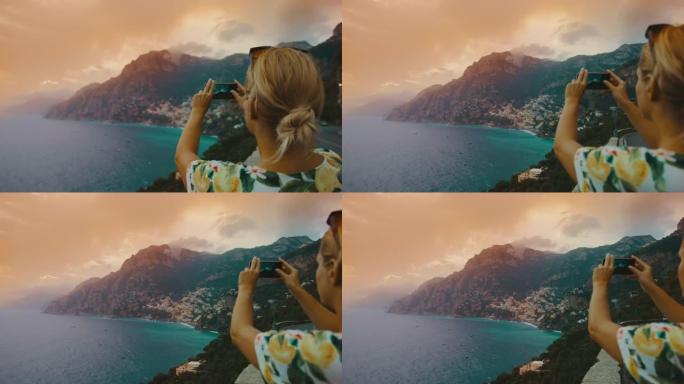 SLO MO女游客在日落时使用手机拍摄阿马尔菲海岸