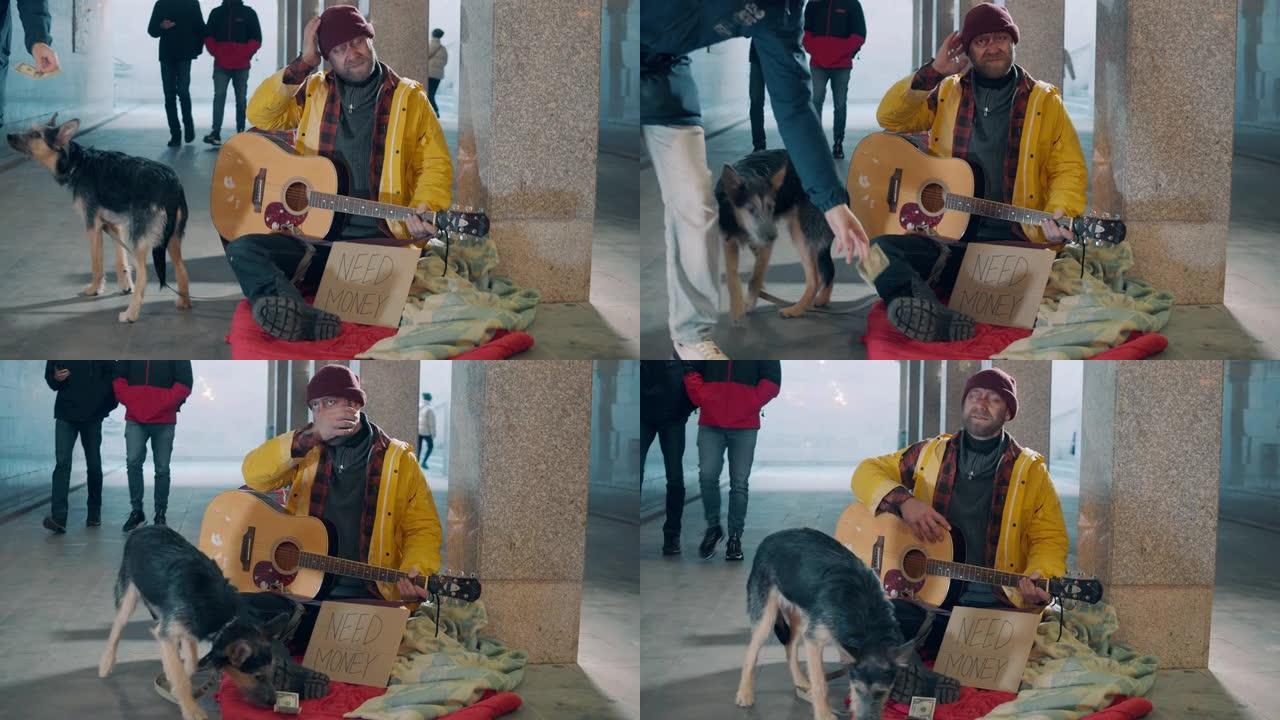 一个无家可归的人拿着吉他和他的狗坐在地上