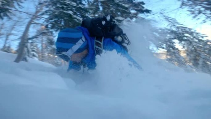 肖像男子在雪中滑落时在山林中滑雪