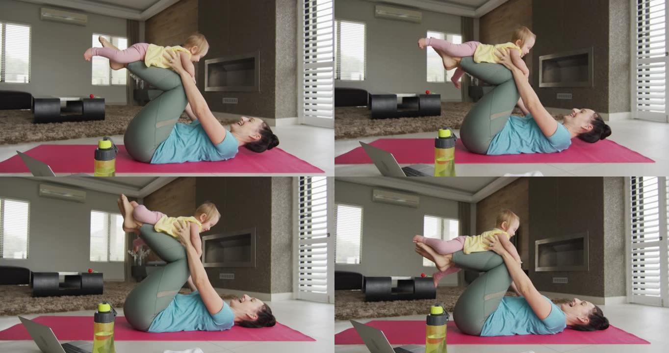 白人母亲在家在瑜伽垫上练习瑜伽时与婴儿玩耍