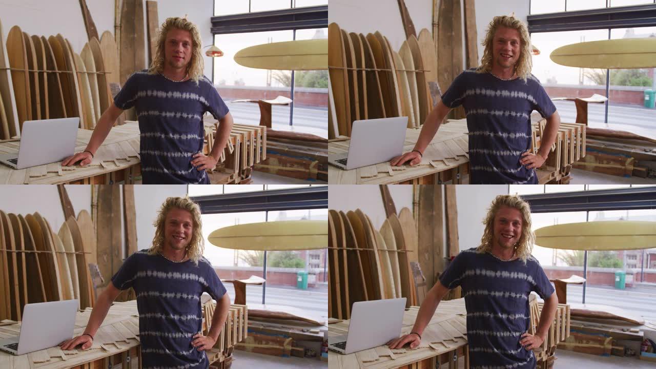 高加索男性冲浪板制造商在他的工作室里，背景是冲浪板