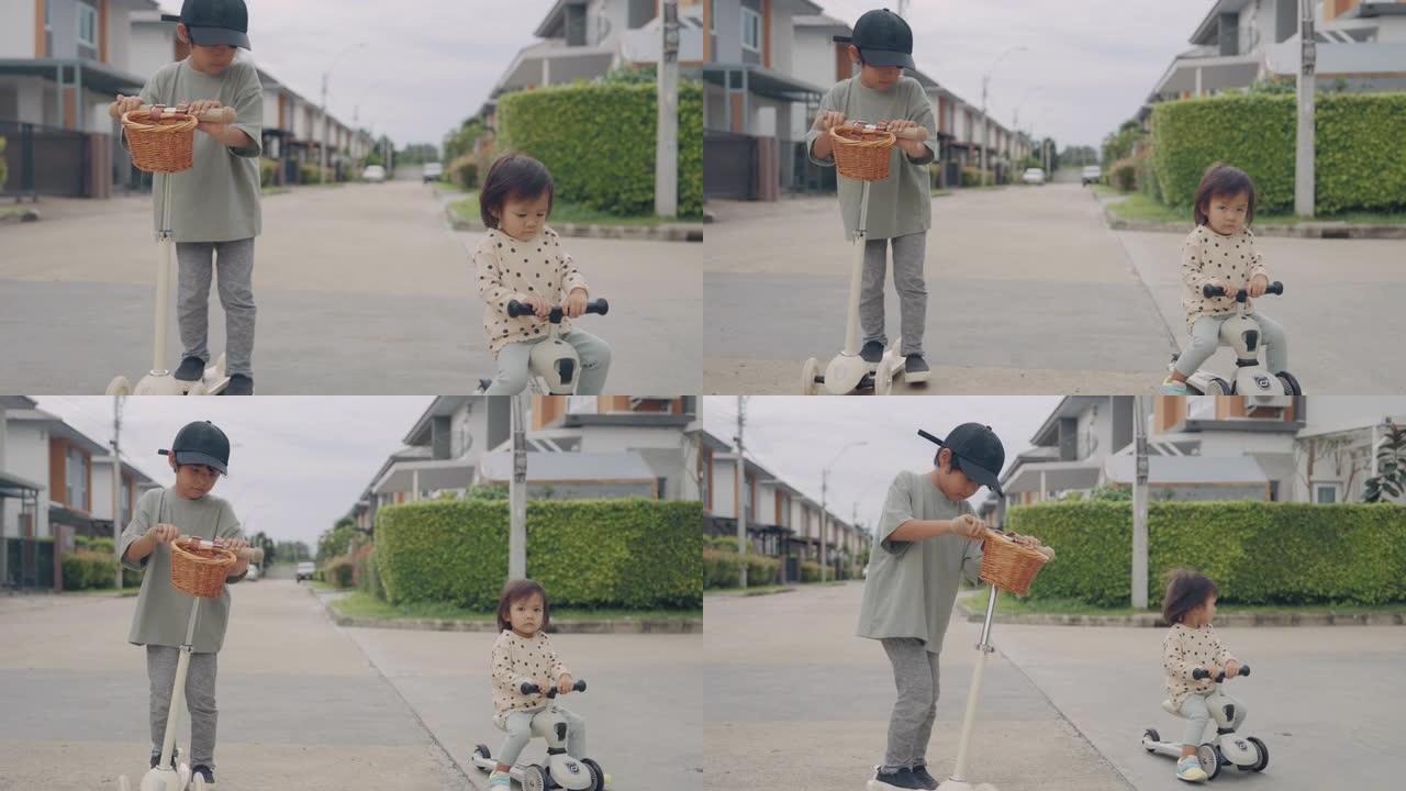 小男孩和他的妹妹骑着一辆踏板车。