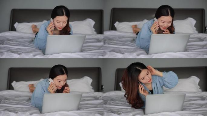 年轻妇女躺在床上使用笔记本电脑并在手机上聊天