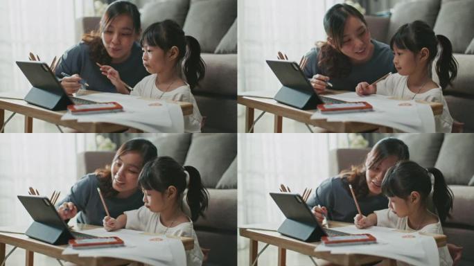 母亲帮助女儿在家上学时使用笔记本电脑