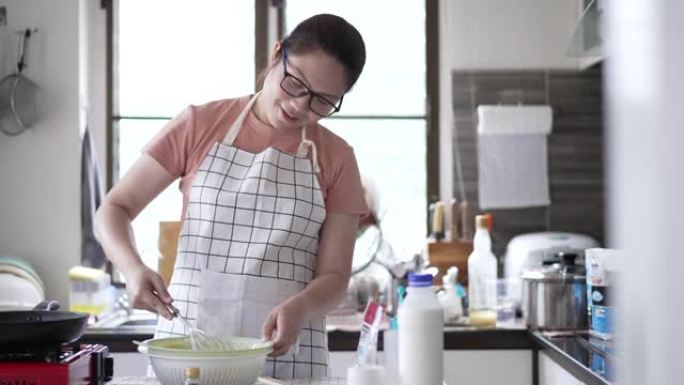 女人在家里的厨房里煮煎饼