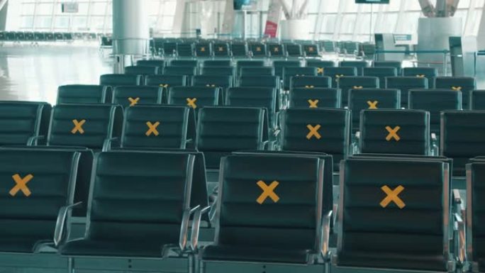 机场标有社交距离的座位。空荡荡的机场航站楼，没有人。大流行，新型冠状病毒肺炎封锁概念。