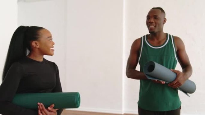 非洲男子在健身房锻炼后与一名女瑜伽教练交谈