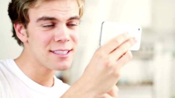 一个年轻人使用智能手机检查牙齿和头发的4k视频片段