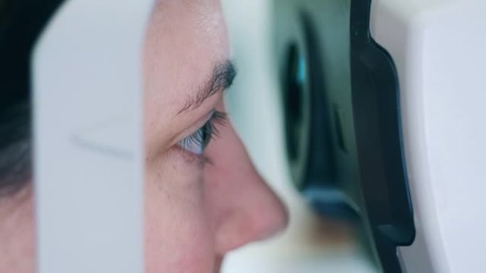 一个女人正在看着眼睛检查机器
