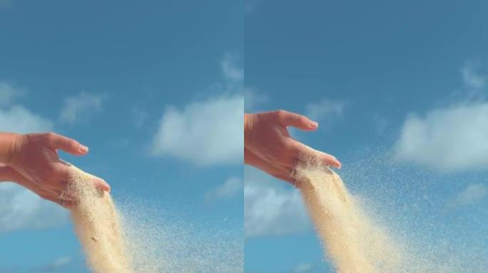 垂直慢动作: 微小的沙粒从女性手中吹出。