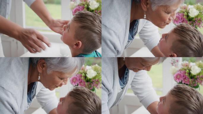 祖母轻轻地亲吻额头上的小男孩，表示对孙子的爱骄傲的奶奶感受到对孙子4k的爱