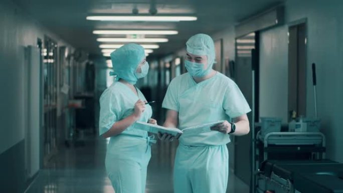 两名外科医生正在走廊上讨论文件