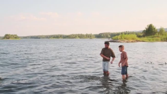 男子和男孩扔石头站在湖里