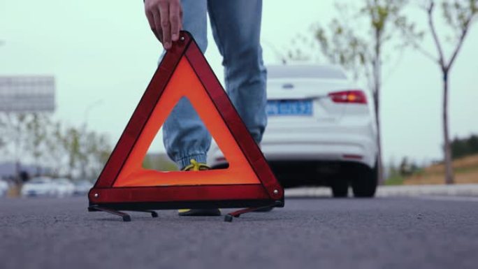 男子在道路上放置红色警告三角形