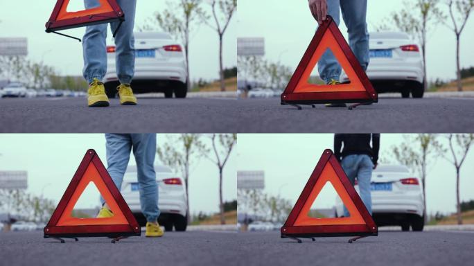 男子在道路上放置红色警告三角形