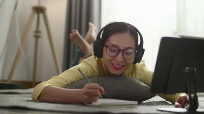 年轻的亚洲女性是家庭学校，在数字平板电脑、家庭生活、家庭工作、新工作场所进行电子学习