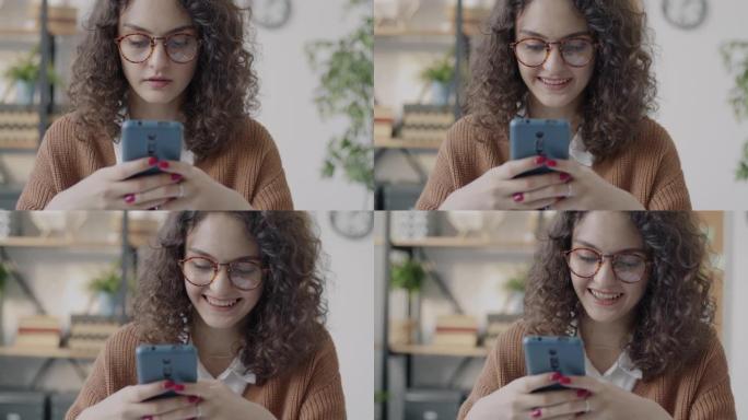 女性员工使用智能手机发短信阅读信息并微笑着独自在办公室工作